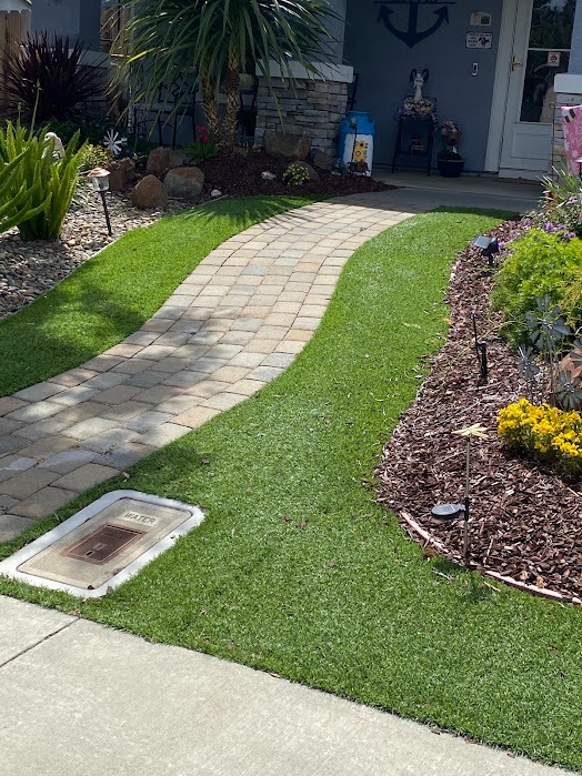 Curved paver walkway bordered by turf